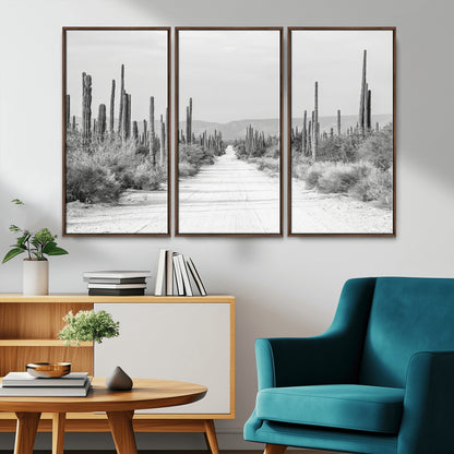 A black and white desert road stretching through a cactus-filled landscape, creating a rugged and timeless southwestern aesthetic with a sense of adventure.