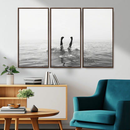 A black and white minimalist water scene capturing a playful splash as a swimmer dives upside down, creating a carefree and artistic aquatic aesthetic.