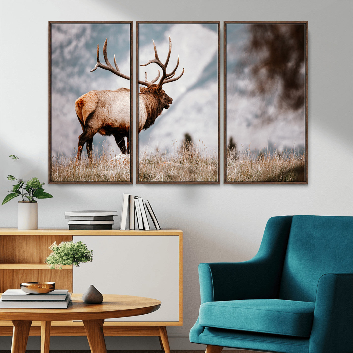 Majestic elk with large antlers standing in grass with snowy mountains in background, perfect for rustic cabin or lodge style decor.