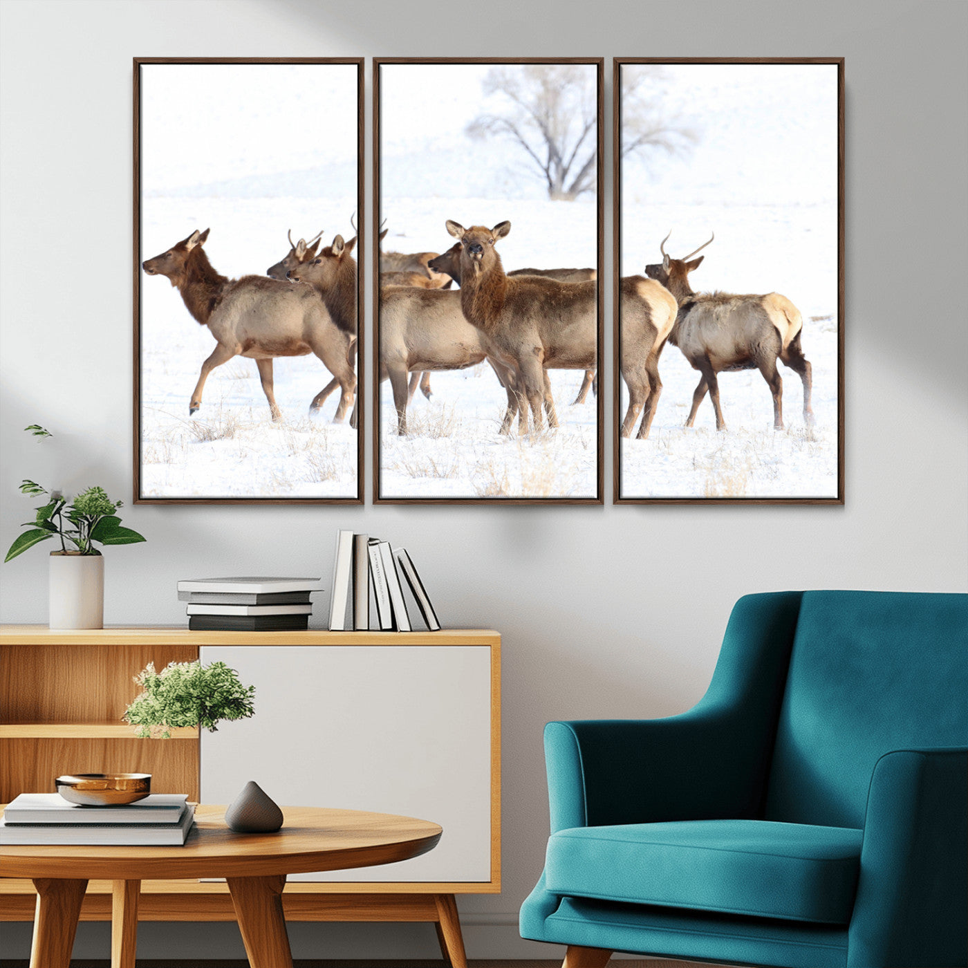 A group of elk standing on snowy terrain with a tree in the background, perfect for rustic or lodge-style winter wall decor.