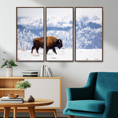 A lone bison walks across snowy ground with blue-toned mountain range behind, ideal for rustic or western farmhouse interiors.