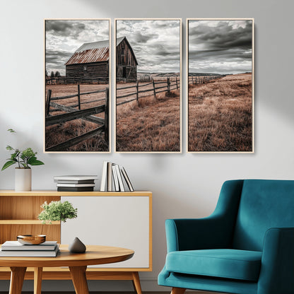Framed canvas of a rustic barn under a moody sky with weathered fence and dark fields, ideal for farmhouse or rural-style wall decor.