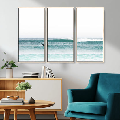 Minimalist photo of a lone surfer on calm aqua waves under bright sky, perfect for Scandinavian coastal or serene ocean-inspired home decor.