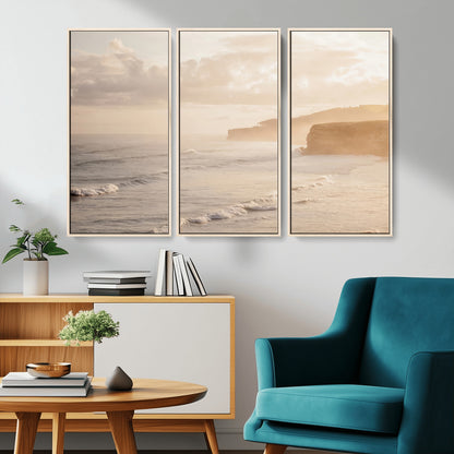 Golden hour seascape with misty cliffs and gentle waves rolling towards the shore, capturing a tranquil and warm coastal atmosphere.