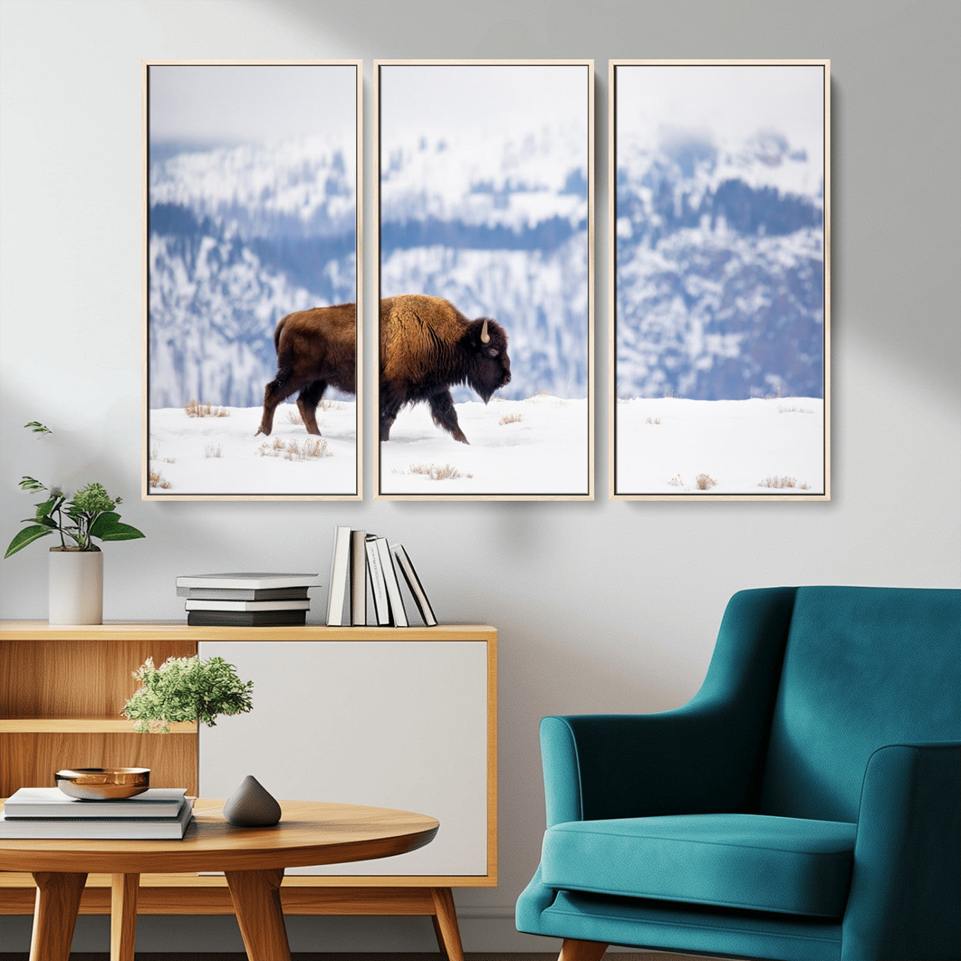 A lone bison walks across snowy ground with blue-toned mountain range behind, ideal for rustic or western farmhouse interiors.