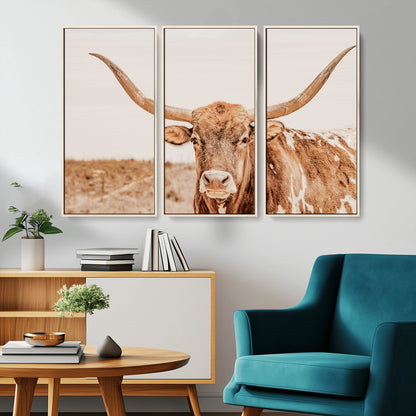 A longhorn bull standing proudly in a sunlit desert field with warm neutral tones, ideal for rustic western or farmhouse interiors.
