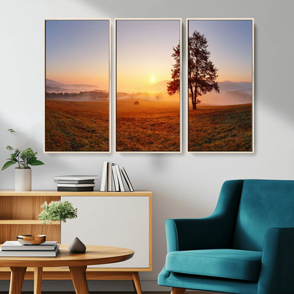 A tranquil landscape at sunrise with a mist-covered field and a lone tree, creating a peaceful and natural atmosphere.