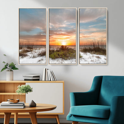 A tranquil beach scene featuring golden sunset hues over the water, with grasses in the foreground and a peaceful, serene atmosphere.