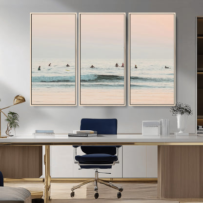 Dreamy photo of surfers waiting on soft pastel waves under a pink sunset sky, ideal for soft coastal minimalist or serene ocean-themed home decor.