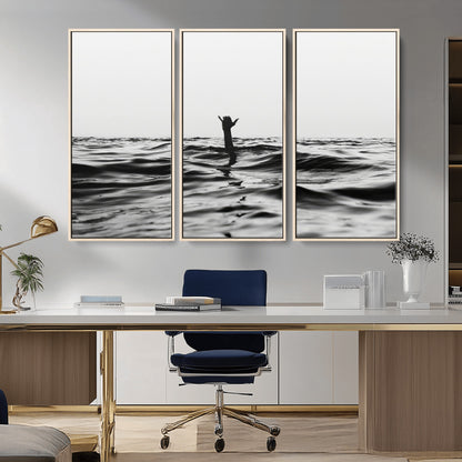 Black and white ocean with a hand making a surfer sign among dark waves, creating a dramatic and minimalist seascape with bold contrast.