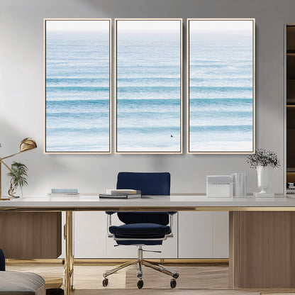 Minimalist ocean view with soft blue waves and a lone surfer, creating a serene and airy coastal aesthetic, perfect for tranquil home decor.