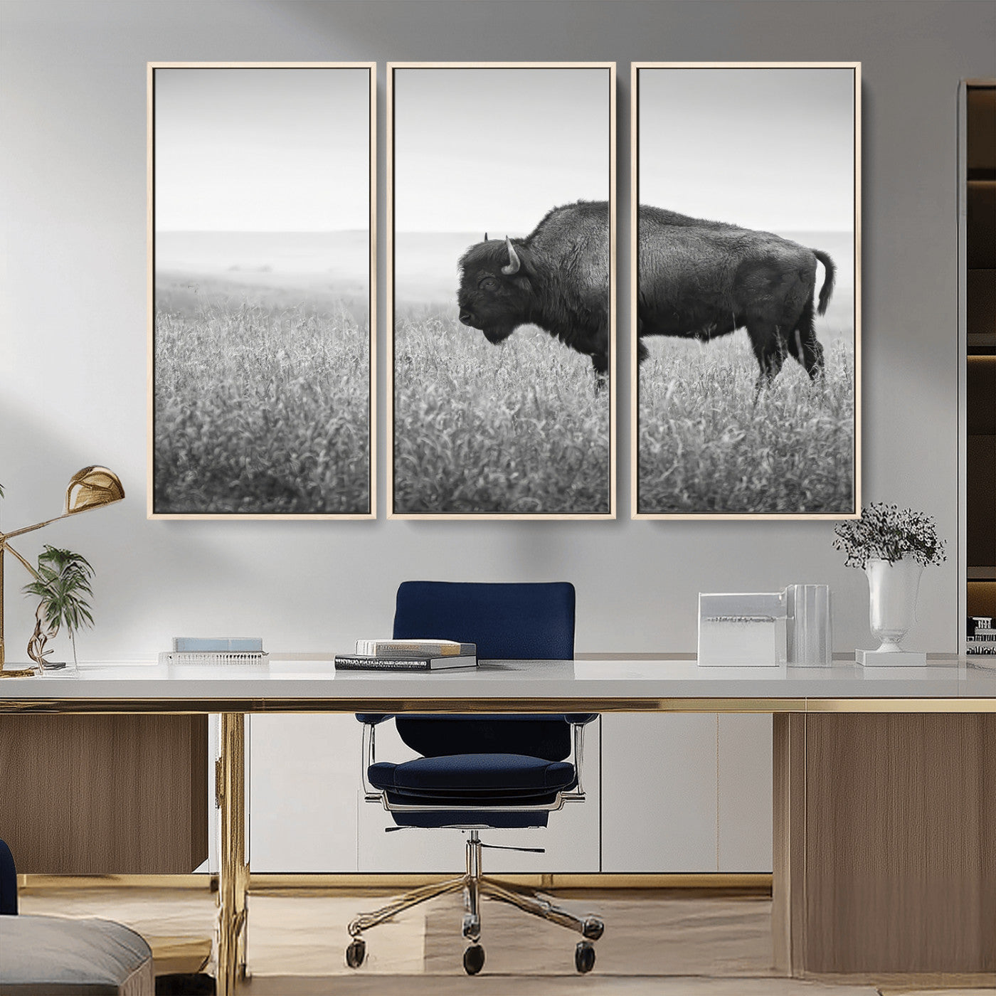 A black and white photograph of a majestic bison standing in a vast grassy prairie, evoking a sense of wilderness and strength.