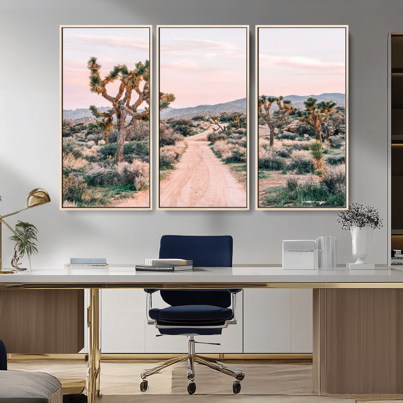 A dusty road winding through Joshua Tree National Park, framed by iconic twisted trees and warm desert tones under a soft pastel sky.