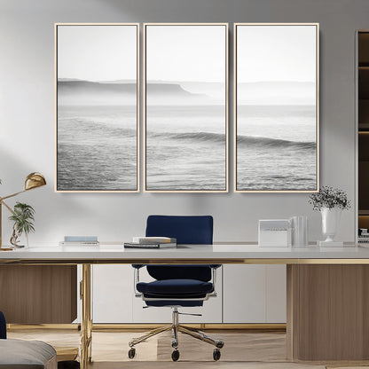 A black and white minimalist seascape featuring soft rolling waves and misty distant cliffs, creating a serene and timeless coastal atmosphere.