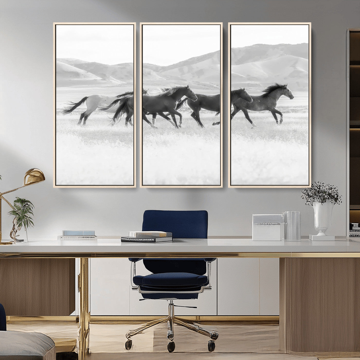 A black and white image of wild horses running freely across an open grassland, capturing the power and beauty of untamed nature in a rustic western setting.