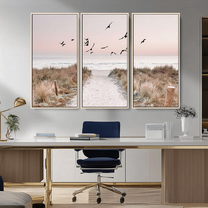 A peaceful coastal pathway leading to the ocean, with birds flying across a soft pastel sky, creating a calm and scenic beach atmosphere.