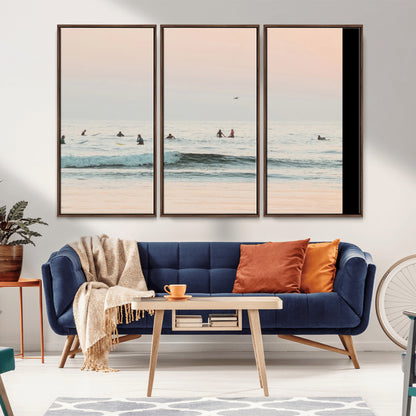 Dreamy photo of surfers waiting on soft pastel waves under a pink sunset sky, ideal for soft coastal minimalist or serene ocean-themed home decor.