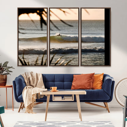 Photo of a surfer riding a golden hour wave at sunset, with tropical tones and dreamy light, perfect for tropical boho or coastal home decor.