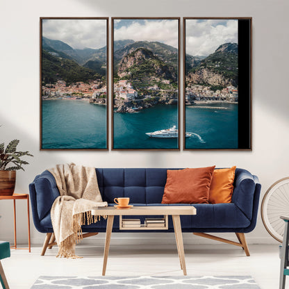 Aerial view of Amalfi Coast, Italy, with colorful hillside houses, lush green mountains, and a luxury yacht sailing in turquoise waters.