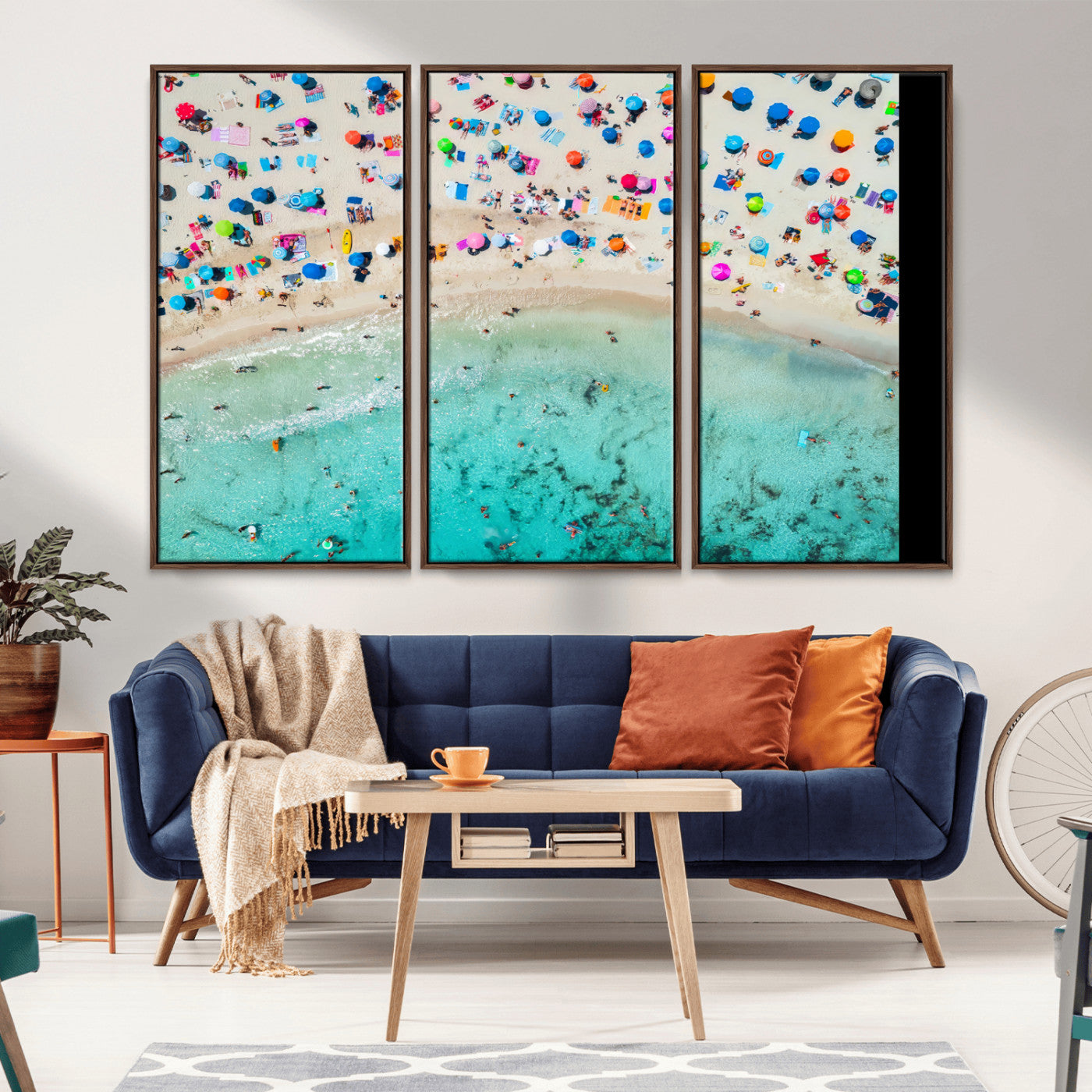 Aerial view of a vibrant beach filled with colorful umbrellas and people enjoying the turquoise ocean, capturing a lively summer vacation scene.