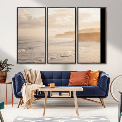 Golden hour seascape with misty cliffs and gentle waves rolling towards the shore, capturing a tranquil and warm coastal atmosphere.