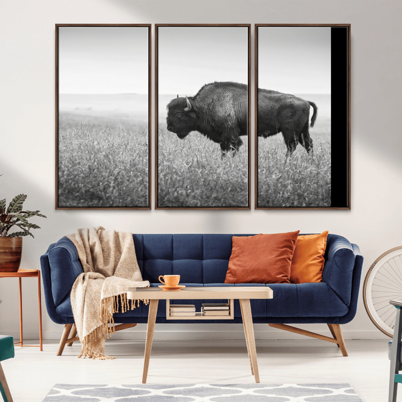 A black and white photograph of a majestic bison standing in a vast grassy prairie, evoking a sense of wilderness and strength.