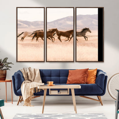 A herd of wild horses galloping through a sunlit desert plain with mountains in the background, perfect for rustic or western-themed wall decor.