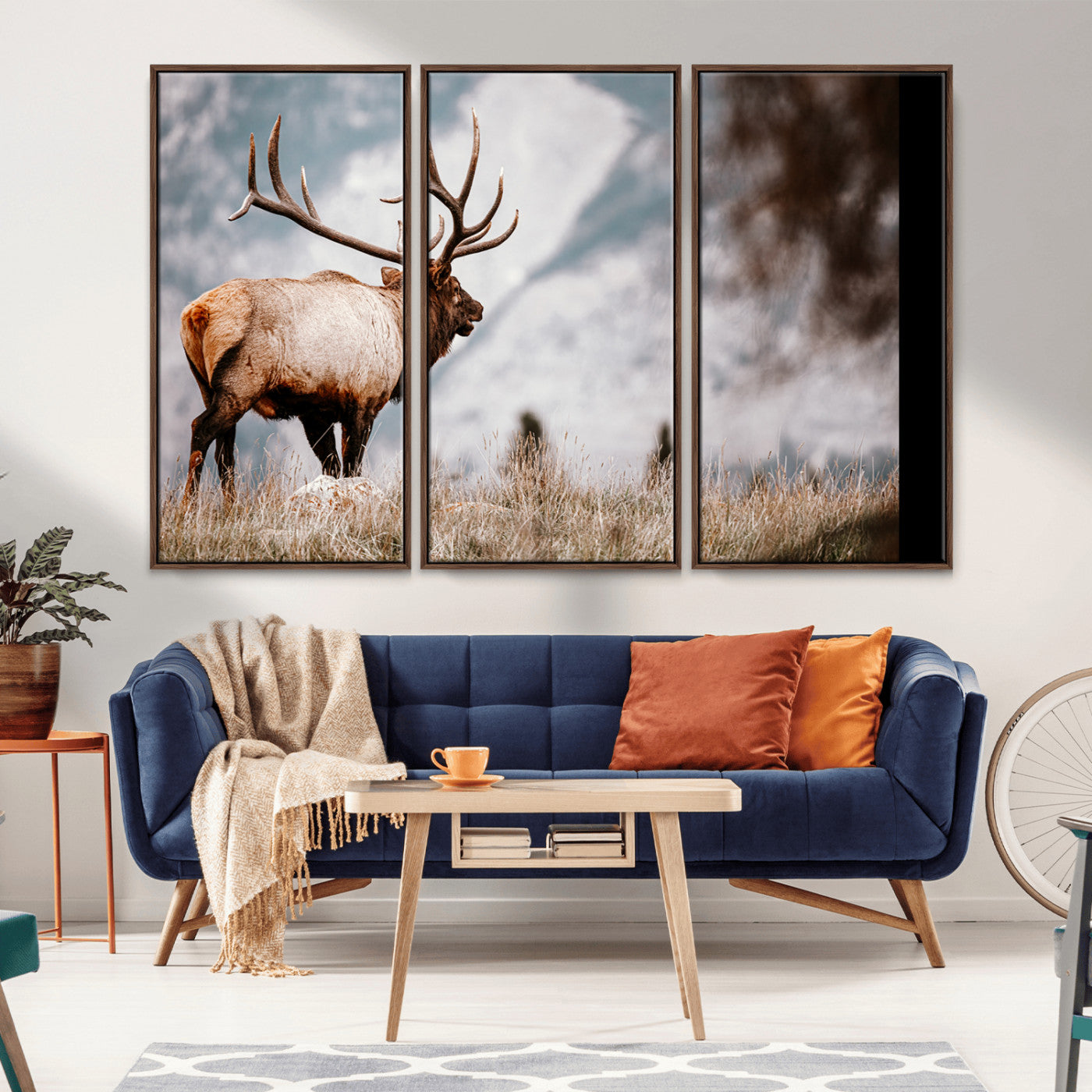 Majestic elk with large antlers standing in grass with snowy mountains in background, perfect for rustic cabin or lodge style decor.
