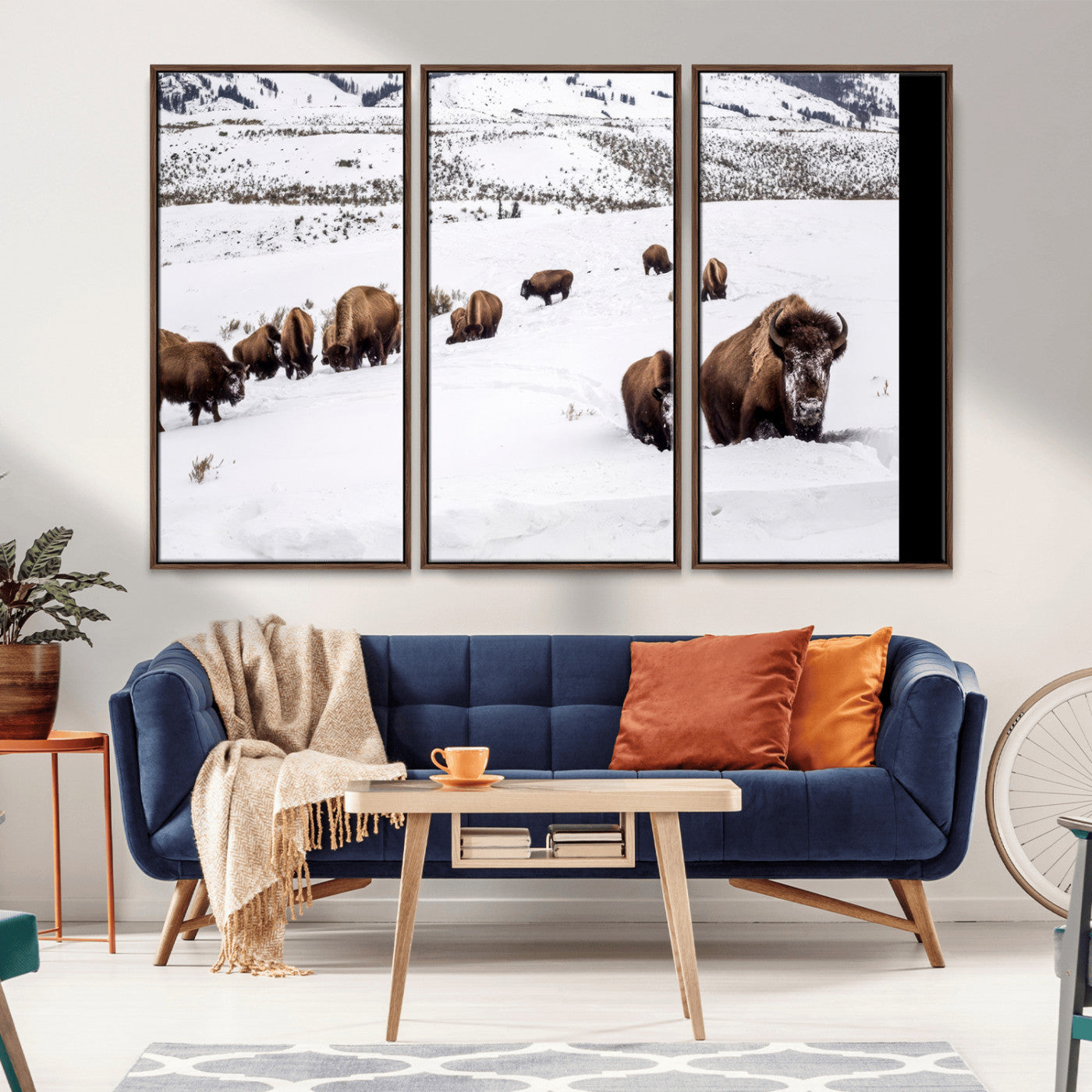 A herd of bison walking through deep snow in a mountain valley, perfect for rustic, cabin or western-themed wall decor.