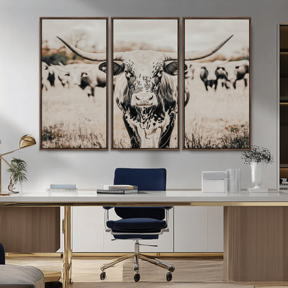 Canvas of a speckled Texas longhorn standing boldly in a field with a herd behind, perfect for rustic western or farmhouse wall decor.