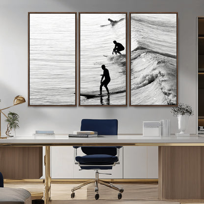 Black and white photo of surfers riding waves in a moody, high-contrast scene, ideal for modern coastal or surf-inspired home decor.