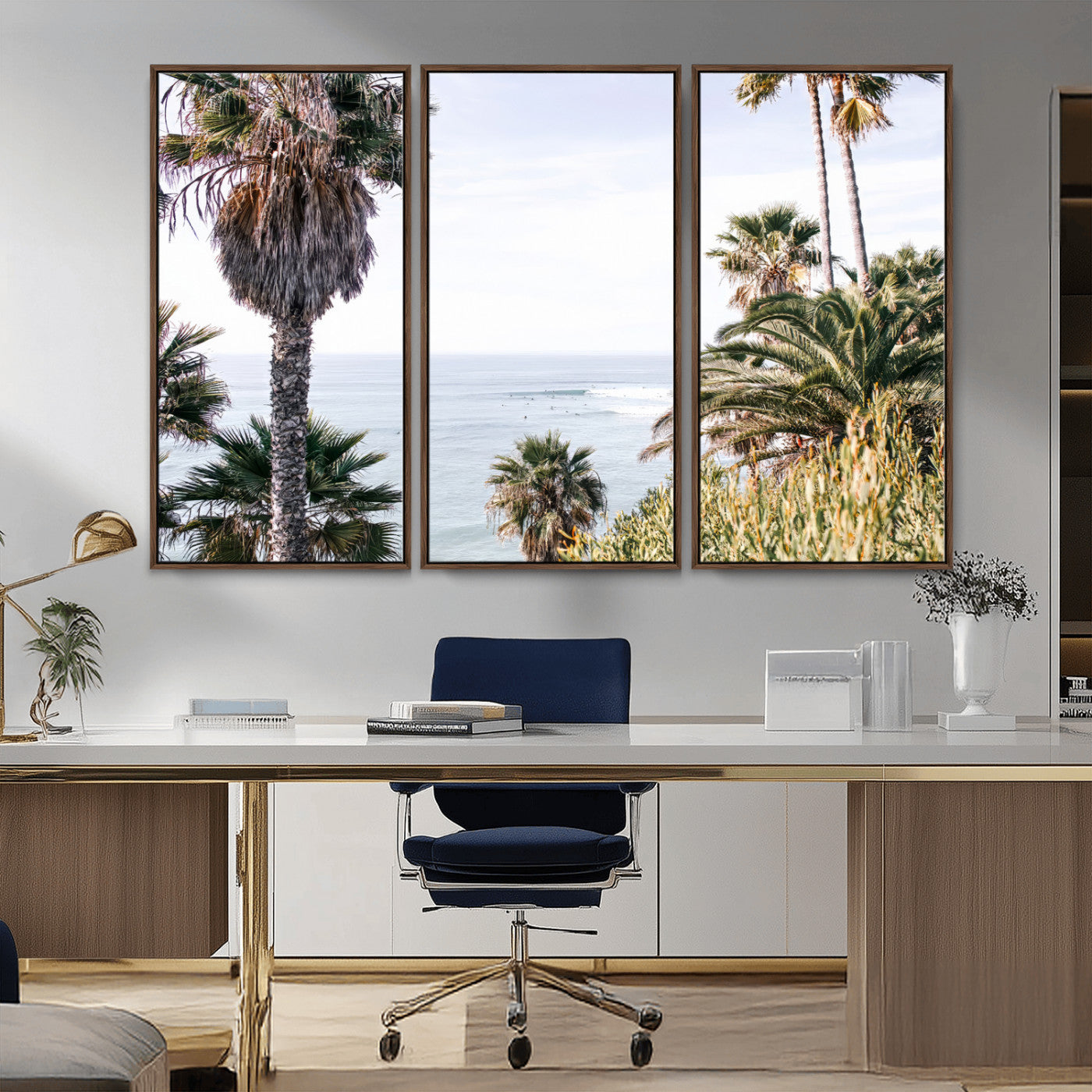Scenic coastal view with tall palm trees overlooking a calm ocean, soft blue waves, and surfers in the distance, creating a peaceful tropical vibe.