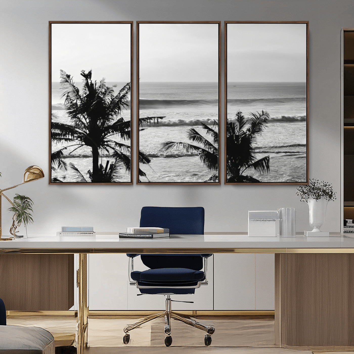 Black and white view of ocean waves crashing on a tropical coastline, framed by silhouetted palm trees under a vast, open sky.
