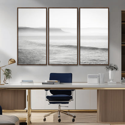 A black and white minimalist seascape featuring soft rolling waves and misty distant cliffs, creating a serene and timeless coastal atmosphere.