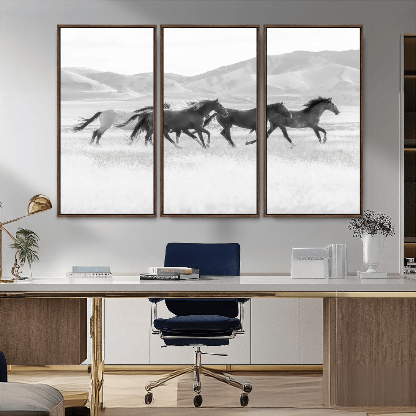 A black and white image of wild horses running freely across an open grassland, capturing the power and beauty of untamed nature in a rustic western setting.