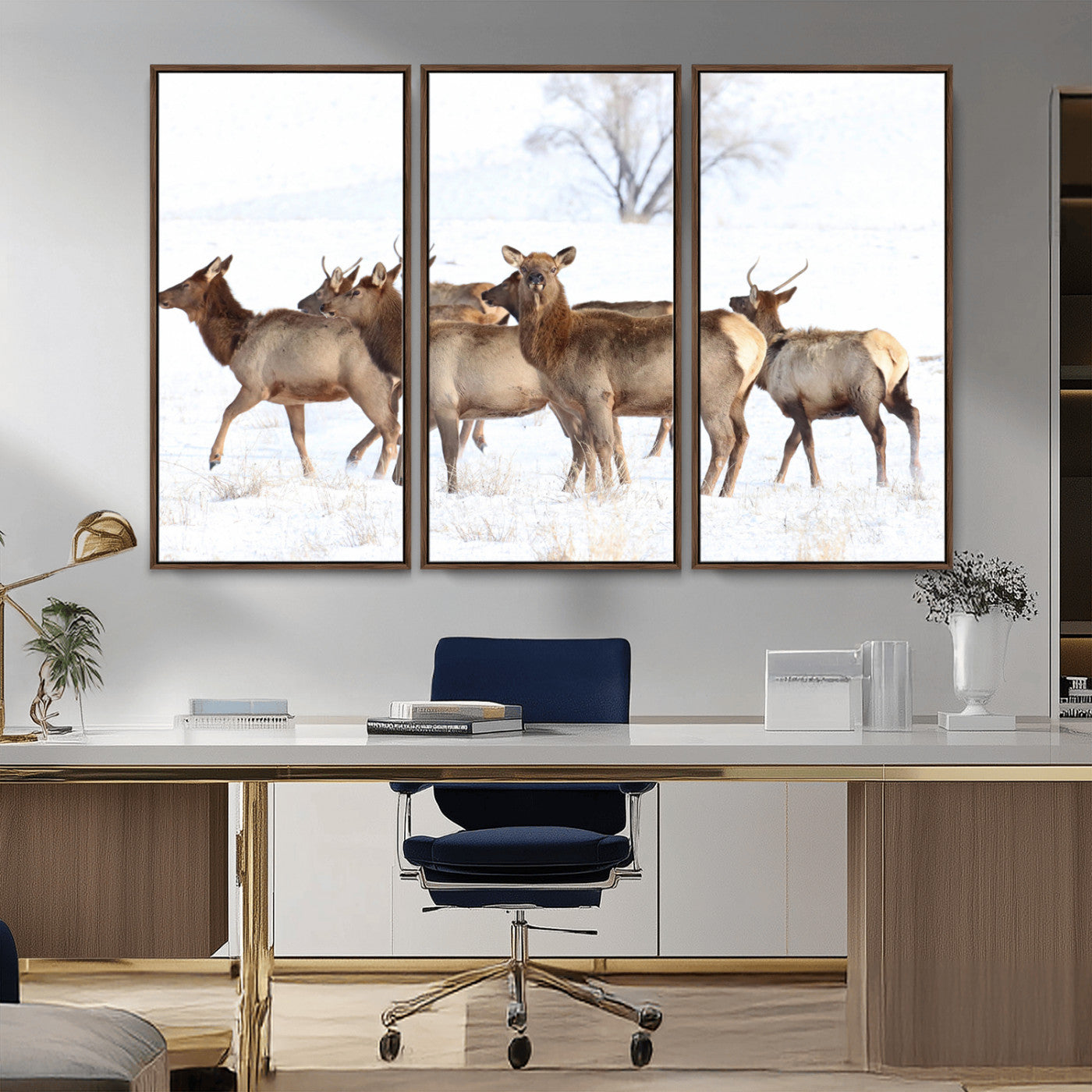 A group of elk standing on snowy terrain with a tree in the background, perfect for rustic or lodge-style winter wall decor.