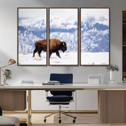 A lone bison walks across snowy ground with blue-toned mountain range behind, ideal for rustic or western farmhouse interiors.