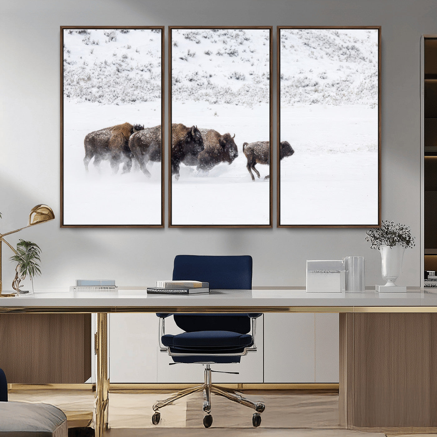 Bison herd running through a snowy open field with mountain backdrop, perfect for rustic or western-themed wall decoration.