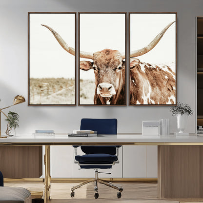 A Texas longhorn bull with wide horns, standing in a dry field under soft light, ideal for rustic farmhouse or western-themed interiors.