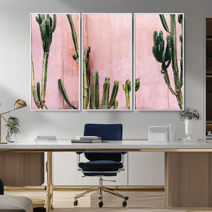 Framed canvas of tall green cacti against a soft pink wall, ideal for modern desert or colorful southwest-inspired home decor.