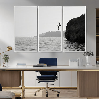 Black and white canvas of two figures cliff jumping into the sea, captured with moody tones, ideal for modern coastal or adventure-themed home decor.   2/2