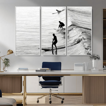 Black and white photo of surfers riding waves in a moody, high-contrast scene, ideal for modern coastal or surf-inspired home decor.