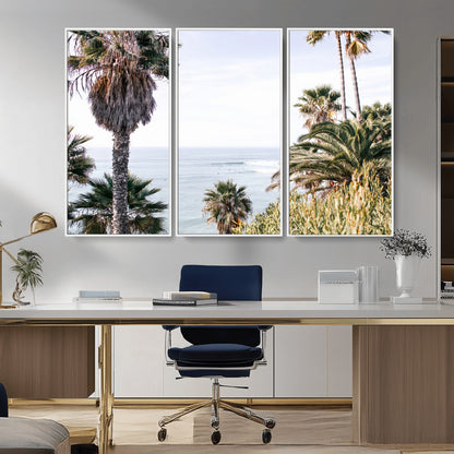 Scenic coastal view with tall palm trees overlooking a calm ocean, soft blue waves, and surfers in the distance, creating a peaceful tropical vibe.