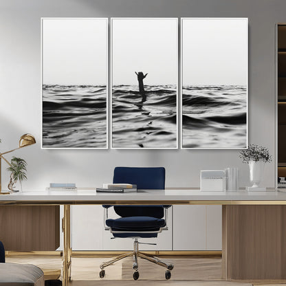 Black and white ocean with a hand making a surfer sign among dark waves, creating a dramatic and minimalist seascape with bold contrast.
