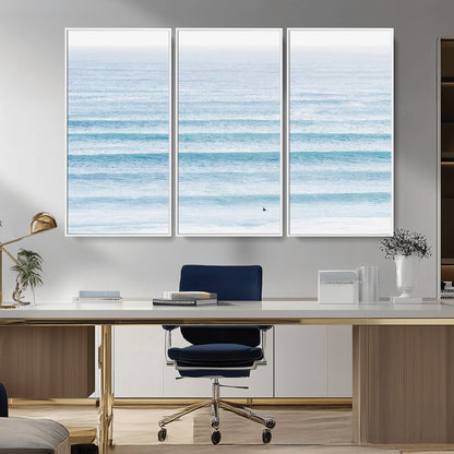 Minimalist ocean view with soft blue waves and a lone surfer, creating a serene and airy coastal aesthetic, perfect for tranquil home decor.