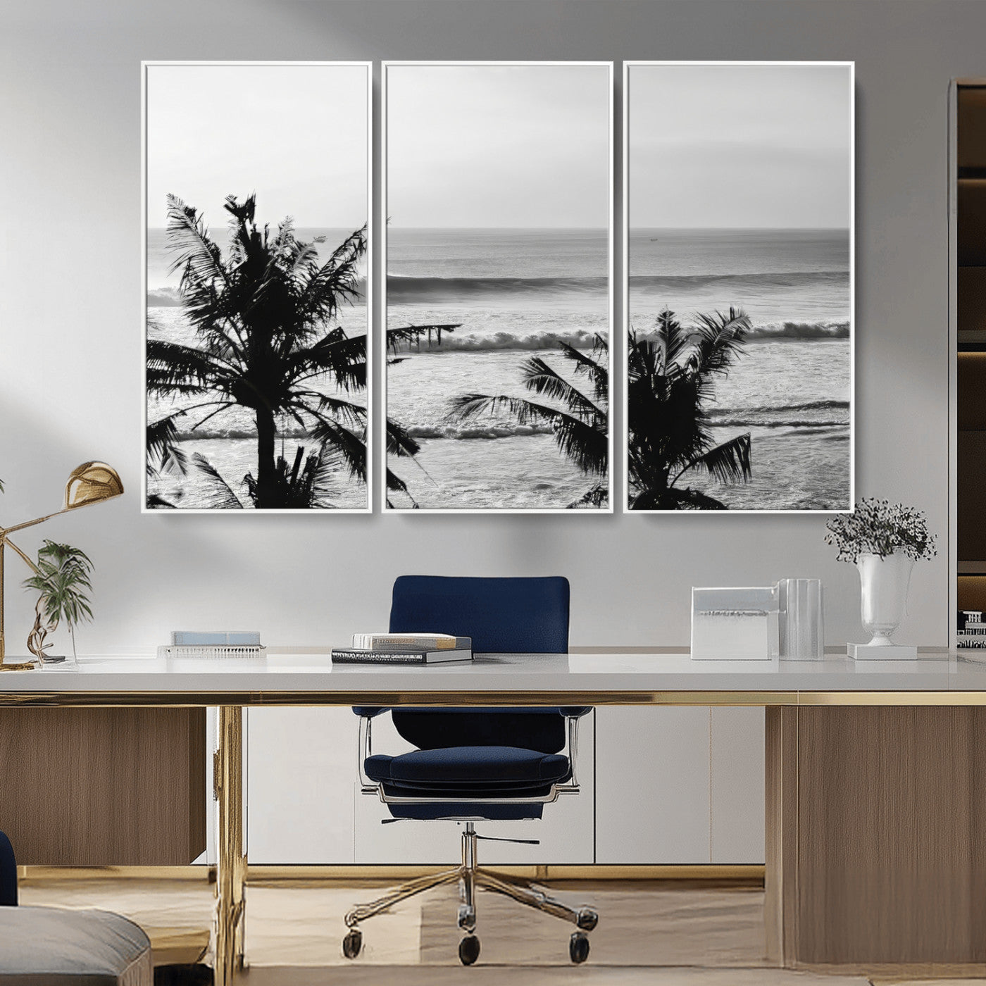 Black and white view of ocean waves crashing on a tropical coastline, framed by silhouetted palm trees under a vast, open sky.