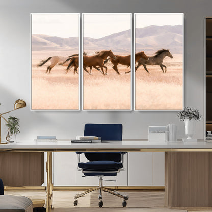 A herd of wild horses galloping through a sunlit desert plain with mountains in the background, perfect for rustic or western-themed wall decor.