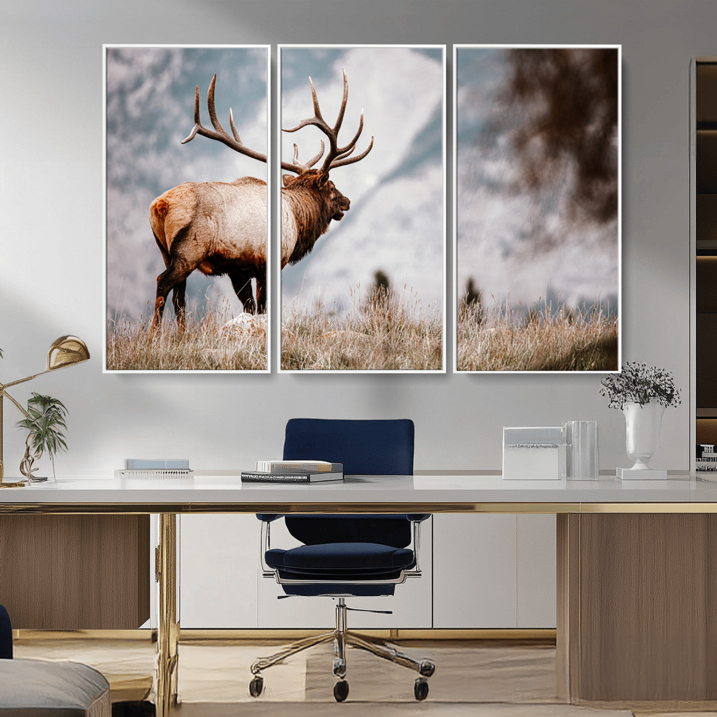 Majestic elk with large antlers standing in grass with snowy mountains in background, perfect for rustic cabin or lodge style decor.