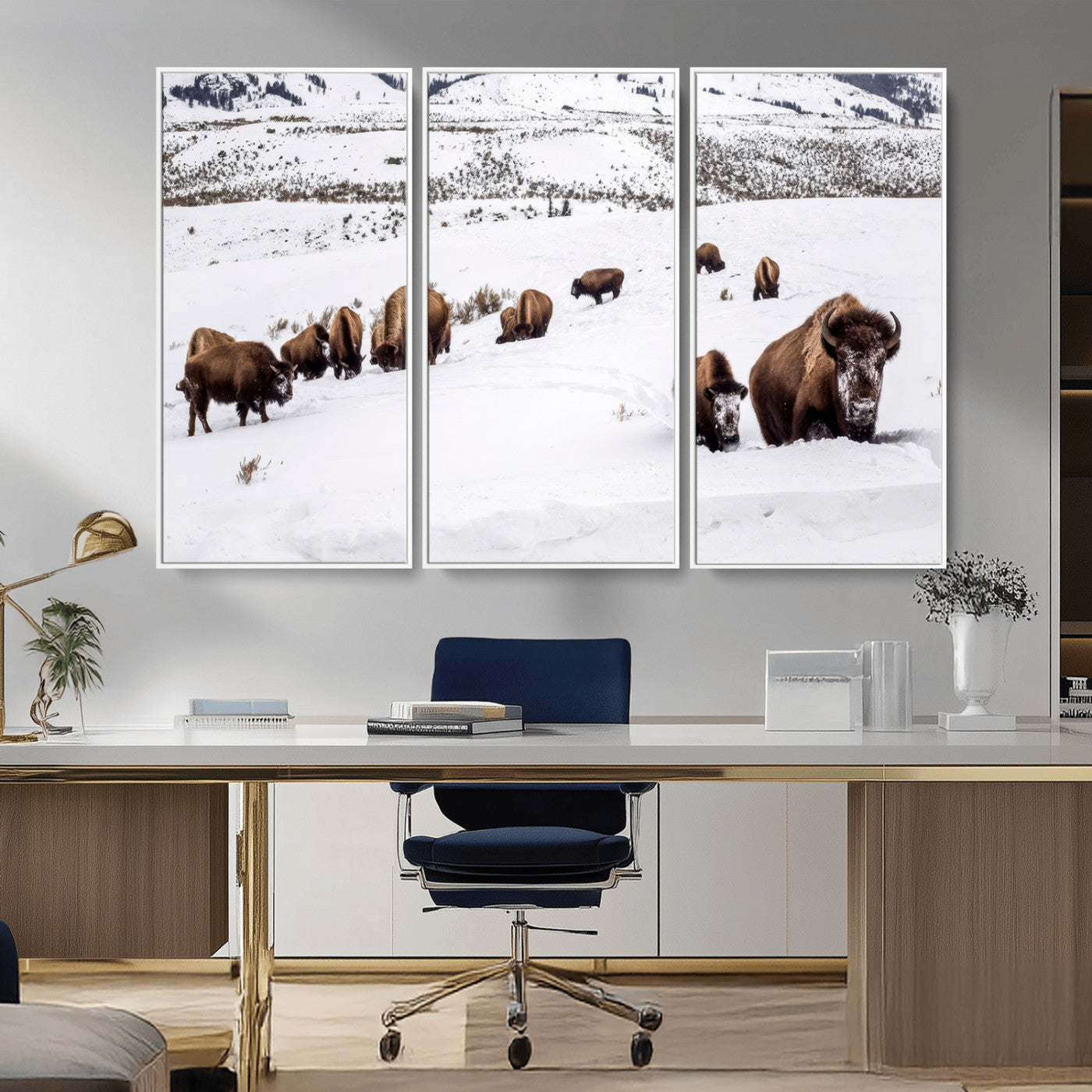 A herd of bison walking through deep snow in a mountain valley, perfect for rustic, cabin or western-themed wall decor.