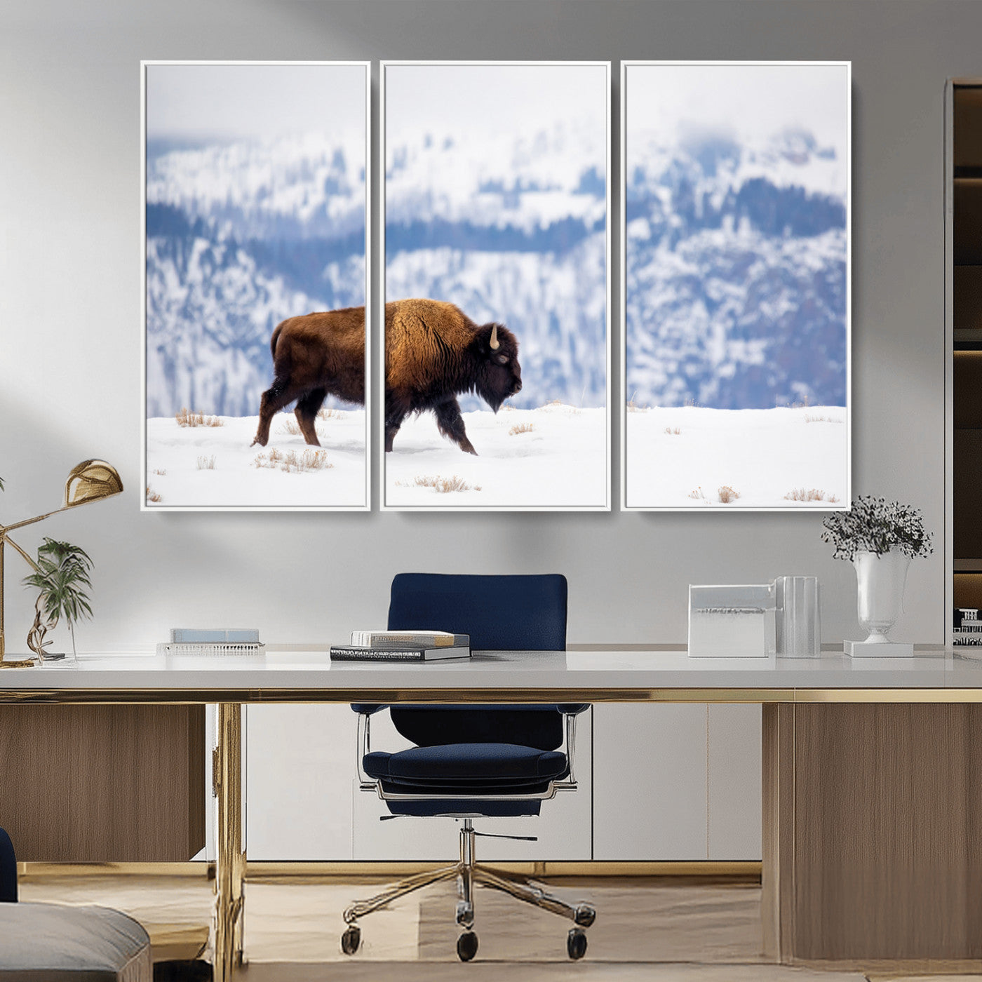 A lone bison walks across snowy ground with blue-toned mountain range behind, ideal for rustic or western farmhouse interiors.